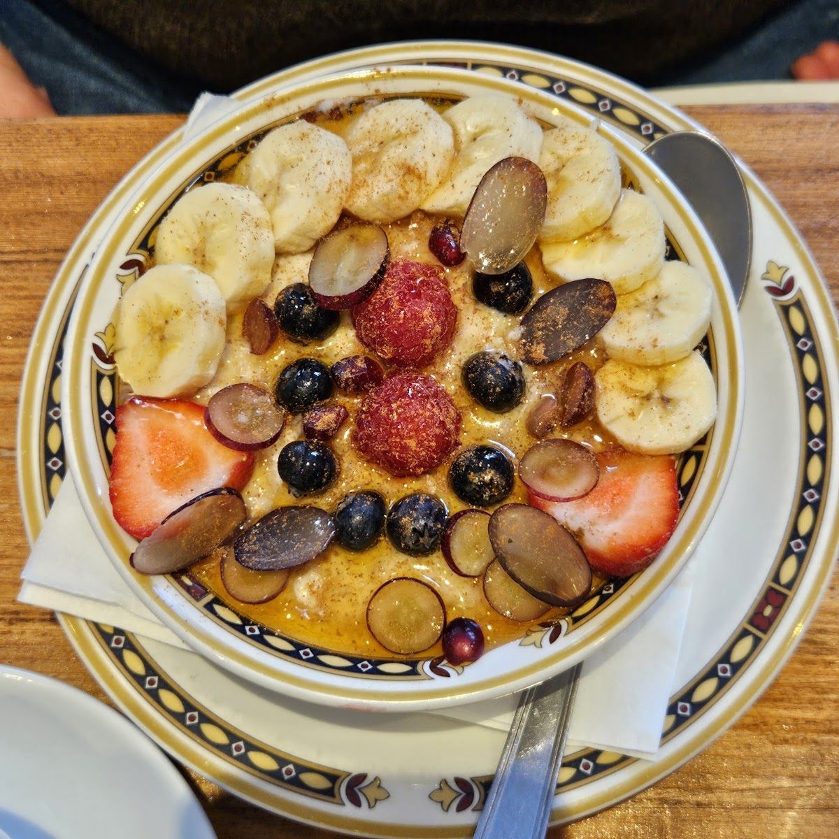 Porridge topped with banana, berries, grapes and cinnamon