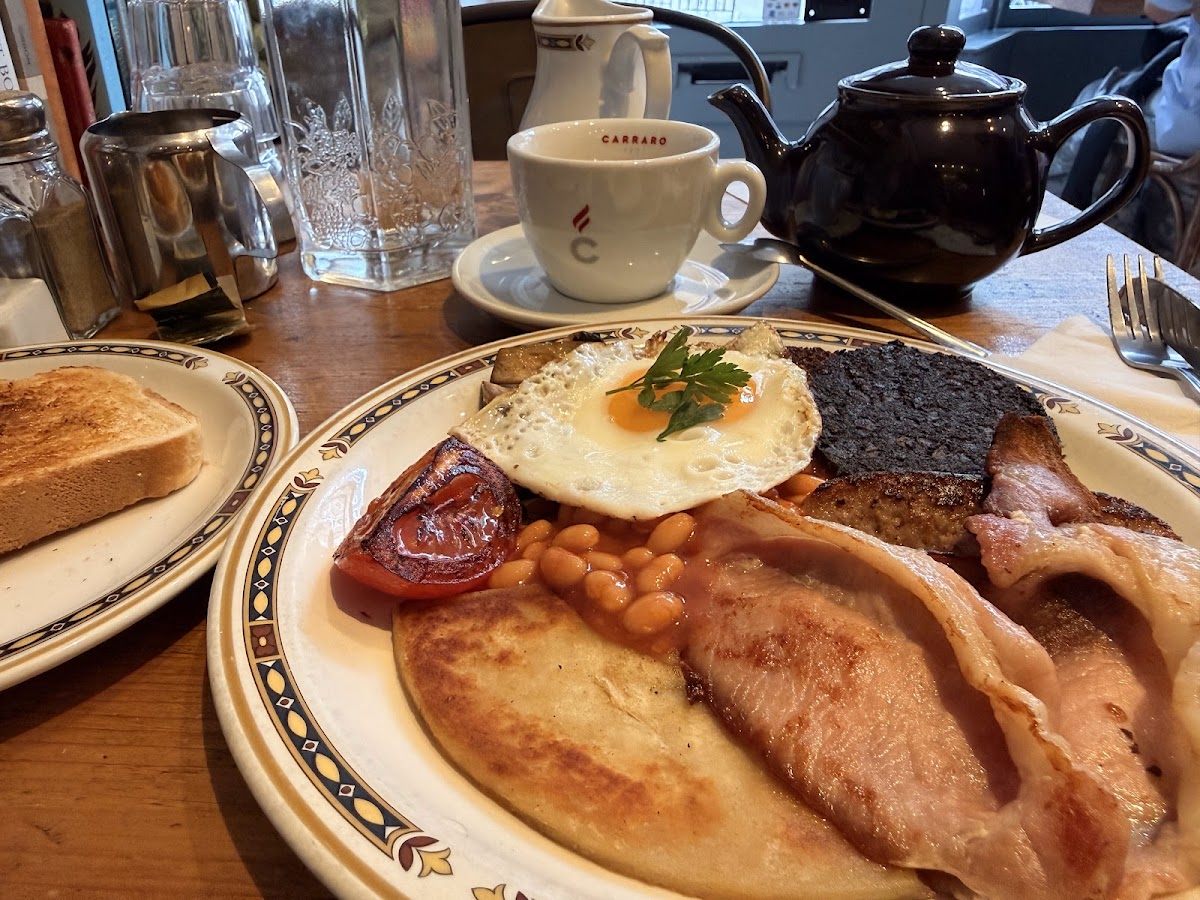 Full Scottish breakfast with a cup of Carraro coffee and a teapot